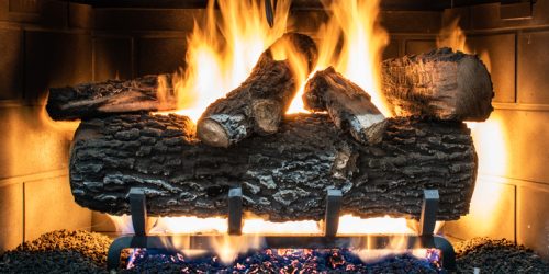 Cozy fireplace with burning logs and vibrant flames creating a warm, inviting ambiance.