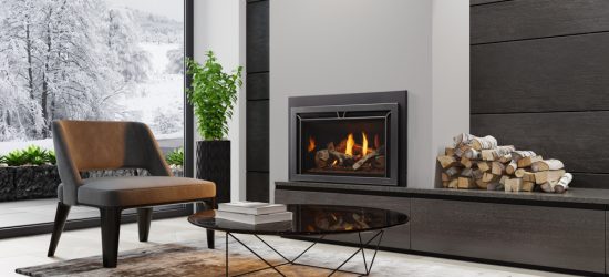 Modern living room with fireplace, chair, and a snowy window view. Logs stacked nearby. Cozy interior design.