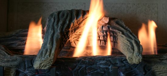 Gas fireplace with realistic logs and bright flames in a cozy home setting.