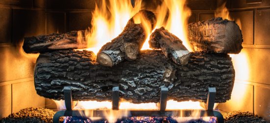 Cozy fireplace with burning logs, creating a warm and inviting atmosphere indoors.