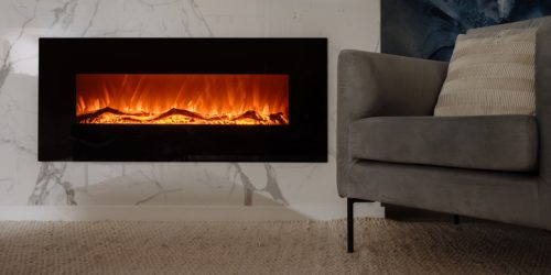 Modern electric fireplace with glowing flames near a gray armchair in a stylish living room.